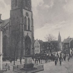 Die St. Johannes-Kirche mit dem Kriegerdenkmal im Vordergrund (heute am Hermann-Johenning-Platz)